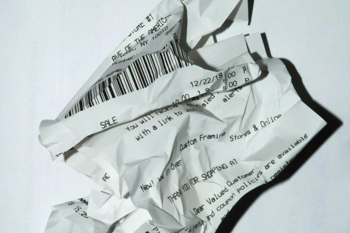 HAULS Journal photo of a crumpled paper shop receipt with a barcode and printed sale line on a white surface