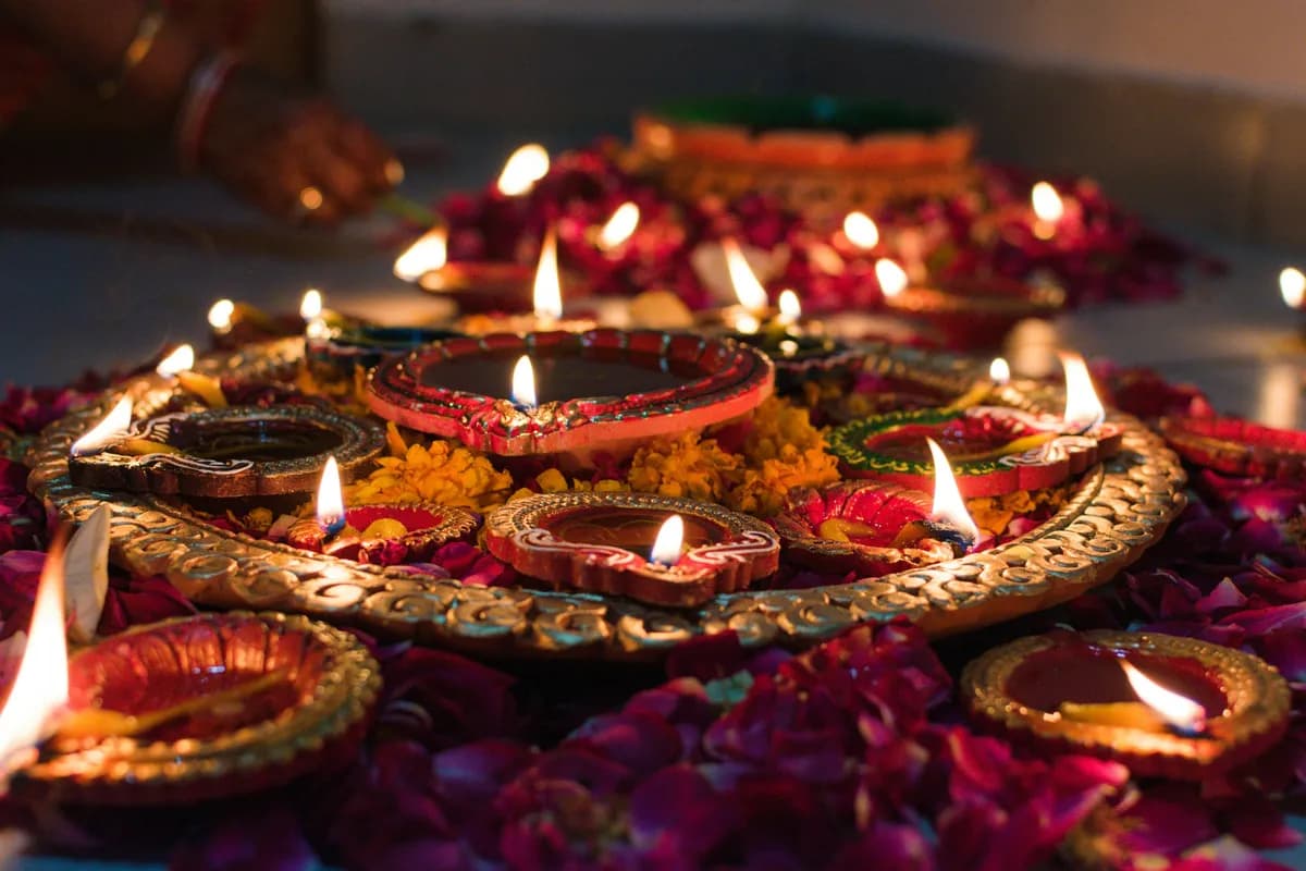HAULS Journal photo of lit clay diyas on a decorated tray with flower petals during Diwali